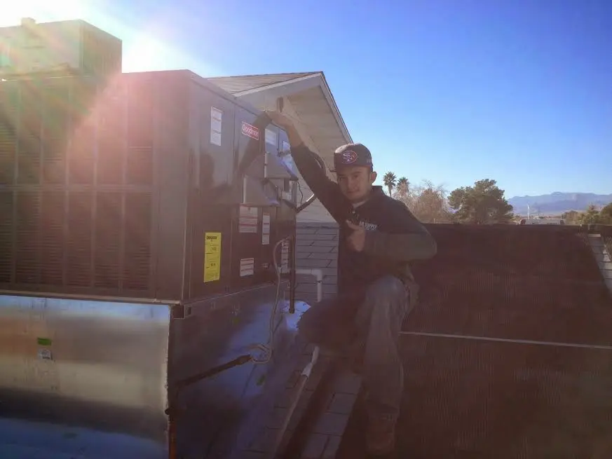 HVAC technician performing HVAC Inspection on a rooftop unit in Westlake